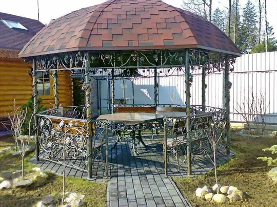 Фото 1 – Беседка, обвитая металлической виноградной лозой
