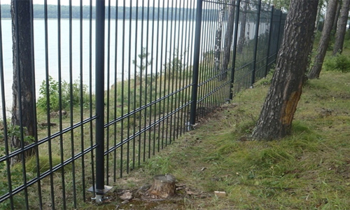 Фото 1 - Забор на винтовых сваях в лесистой местности
