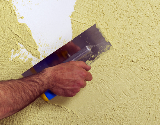 Фото 18 - Обратите внимание на угол наклона кельмы. По нанесению лишний материал со стены нужно снять до толщины зерна