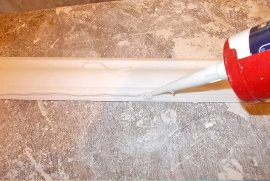 Фото 3 - Клей наносится сплошной линией по краю плинтуса, иначе аккуратно и плотно приклеить его не получится