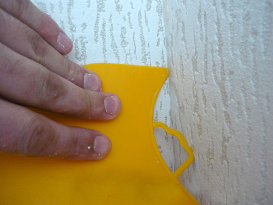 Разравнивание обоев мягким шпателем в углах